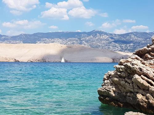 a sail boat in the middle of a body of water at Salt & Stone Villa in Pag