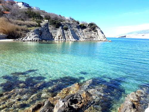 a large body of water with a rocky shore at Salt & Stone Villa in Pag