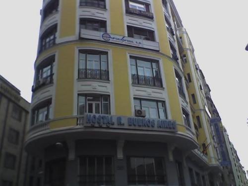 a yellow and white building with a sign on it at Hostal Buenos Aires in Madrid