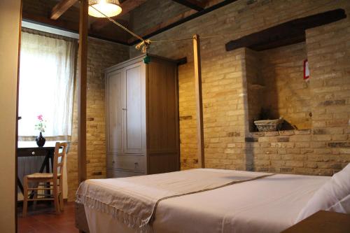 ein Schlafzimmer mit einem Bett und einer Ziegelwand in der Unterkunft Bassarì in Recanati