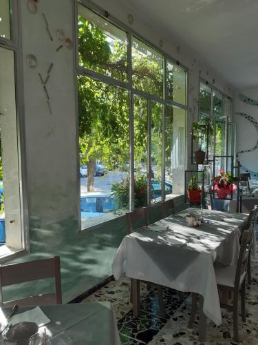 ein Esszimmer mit Tischen und einem großen Fenster in der Unterkunft Hotel Flora in Cesenatico