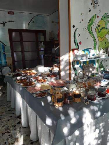 a long table with plates of food on it at Hotel Flora in Cesenatico