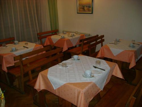 a dining room with three tables with plates and cups at Guest House Robi in Međugorje