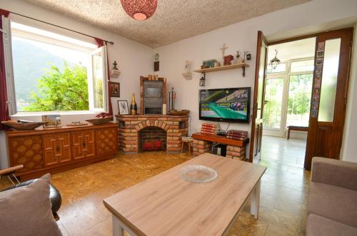 a living room with a table and a fireplace at Guesthouse Grotta Di Nicola in Kotor