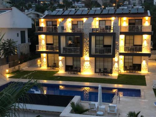 a villa with a swimming pool at night at Stonehouse Aparts Dublex 3+1 mit Meerblick und Jakuzzi Kalkan No:5 in Kalkan