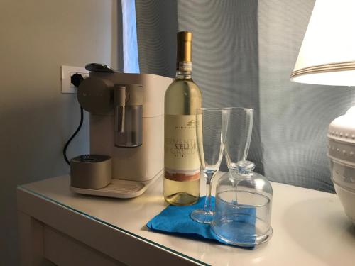 een fles wijn en twee glazen op een tafel bij ESMERALDA'S ROOMS in Porto San Paolo