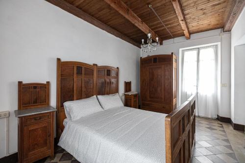 a bedroom with a bed with wooden furniture and a window at Ostello di Germagno in Omegna