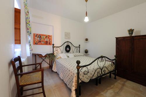 a bedroom with a bed and a chair at Agriturismo L'Aire Alberobello in Alberobello