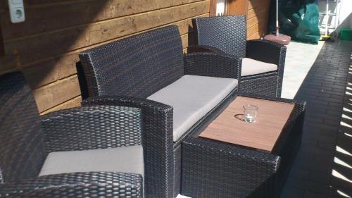 a row of wicker chairs and a wooden table at Appartment Gertrud Flatz in Sankt Anton im Montafon