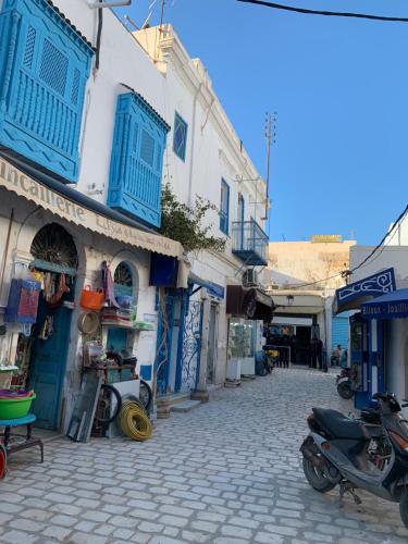a cobblestone street with blue and white buildings at Dar Lola Djerba in Houmt Souk