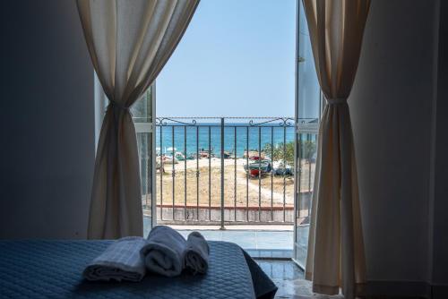 a bedroom with a bed and a view of the ocean at Casa del Sole in Nicotera Marina