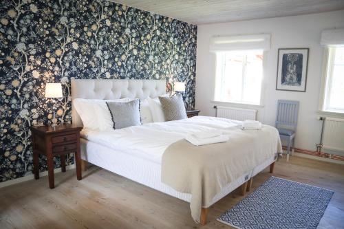 a bedroom with a large bed with a floral wallpaper at SOEDER Countryhouse & Kitchen in Båstad