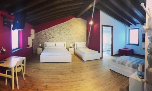 a bedroom with two beds and a table and a desk at Alc&cE' alloggio agrituristico in Povoletto
