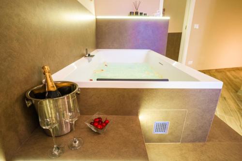 a bath tub with a bottle of champagne next to it at Etnic Suite in Monopoli