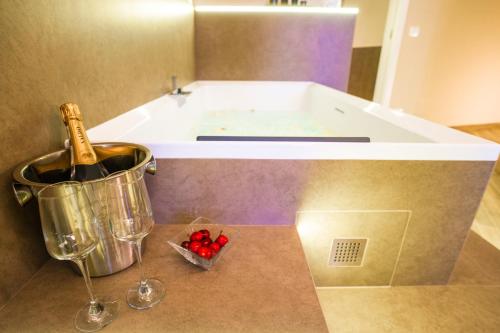 a kitchen with a tub and a bottle of wine and wine glasses at Etnic Suite in Monopoli