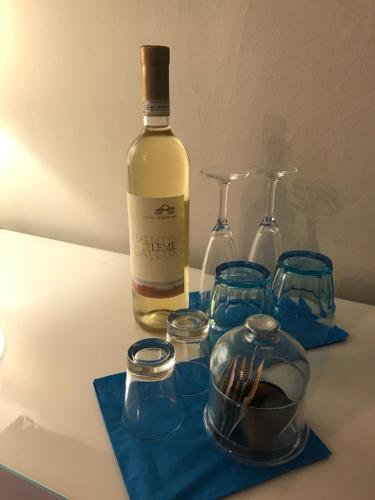 a bottle of wine and glasses on a table at ESMERALDA'S ROOMS in Porto San Paolo