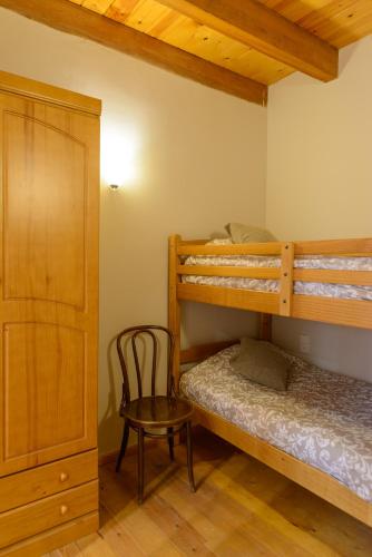 a bedroom with two bunk beds and a chair at Can MiA in Bas
