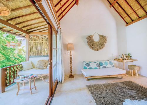 a living room filled with furniture and a window at Mule Malu Tropical Stay in Uluwatu