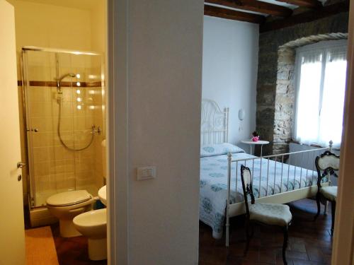 uma casa de banho com uma cama, um chuveiro e um WC. em B&B Gens Julia em Trieste