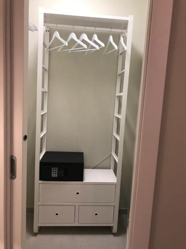 a closet with a white dresser and a mirror at ESMERALDA'S ROOMS in Porto San Paolo