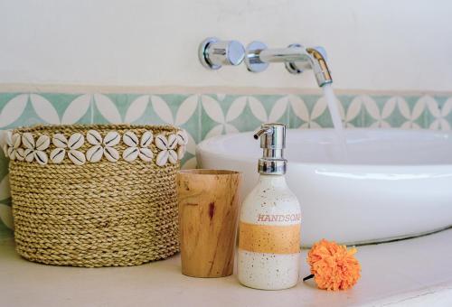 a bathroom sink with soap, toothbrushes, and toothpaste at Mule Malu Tropical Stay in Uluwatu