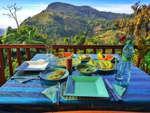 a blue table with plates of food on top of a mountain at Blooming Rose Ella in Ella