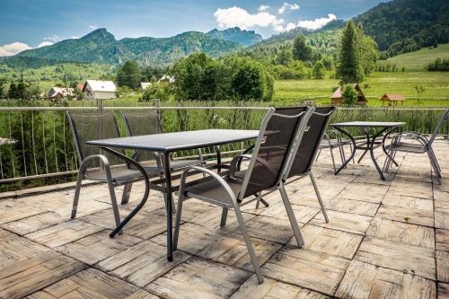 un tavolo e sedie su una terrazza con vista sulle montagne di Apartmány Jánošík a Terchová