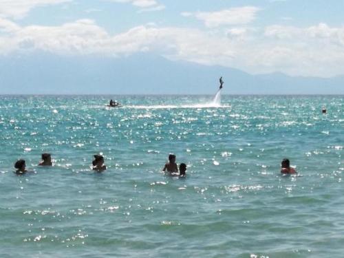 a group of people swimming in the ocean at Crystal Blue Apartments in Nea Kalikratia