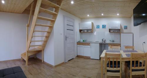 a kitchen and dining room with a spiral staircase in a room at Domki letniskowe i pokoje u Katarzyny in Ustronie Morskie