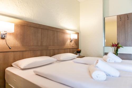 two beds with white pillows in a room at Landhotel Eifelblick in Stadtkyll