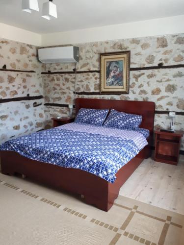 ein Schlafzimmer mit einem Bett in einem Zimmer mit Steinwänden in der Unterkunft Bona's Home in Tushemisht
