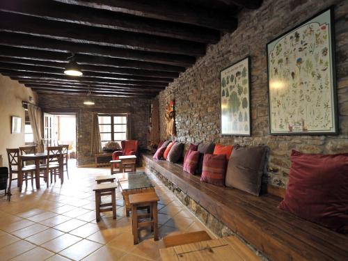 a living room with a long wooden bench with pillows at Los Tres Albares in Lardiés
