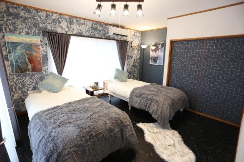 ein Hotelzimmer mit 2 Betten und einem Fenster in der Unterkunft Villent Izu Usami in Ito