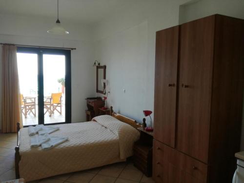 a bedroom with a bed and a dresser and a window at Valeta Studios in Armenistis