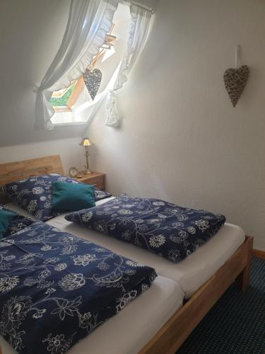 グレーミッツにあるGästehaus Alwine Wohnung 5のベッドルーム1室(青いシーツと窓付きのベッド2台付)