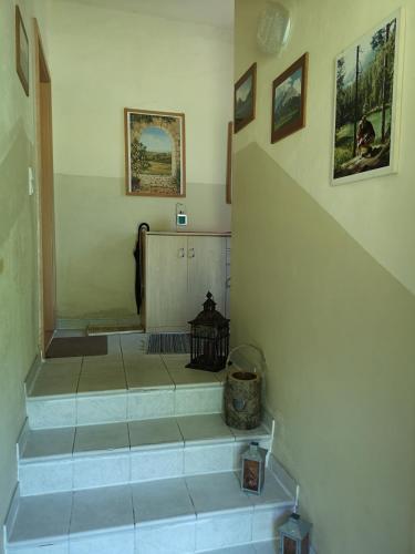 a hallway with stairs in a home with paintings at Ferienwohnung am Wald in Tharandt