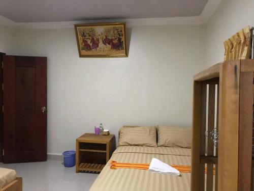 a small bedroom with a bed and a table at Manel Guesthouse and Restaurant in Sen Monorom