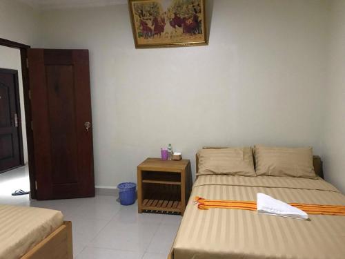 a small bedroom with two beds and a night stand at Manel Guesthouse and Restaurant in Sen Monorom