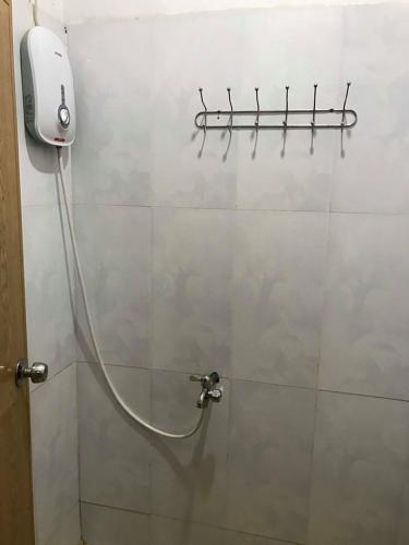 a shower with a hose attached to a wall at Manel Guesthouse and Restaurant in Sen Monorom