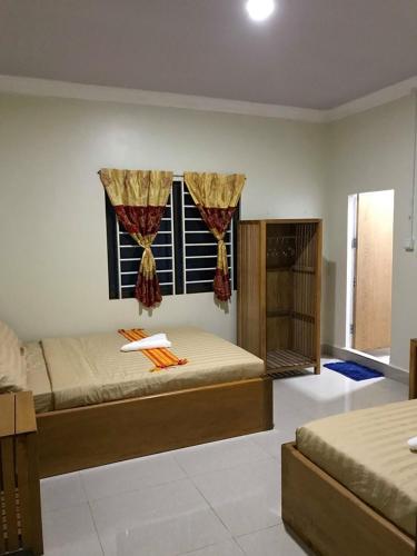 a bedroom with two beds and a window at Manel Guesthouse and Restaurant in Sen Monorom