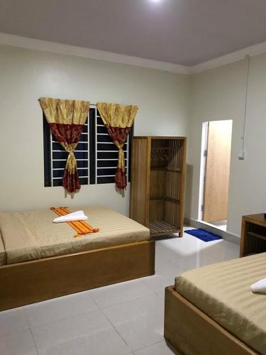 a bedroom with two beds and a window at Manel Guesthouse and Restaurant in Sen Monorom