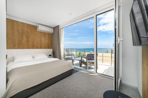 a bedroom with a bed and a view of the ocean at Poseidon Deluxe перша лінія з басейном in Odesa