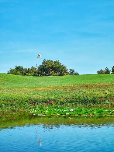 a grassy field with a flag in the middle of a pond at Vipingo Ridge-Swahili Villa in Mombasa