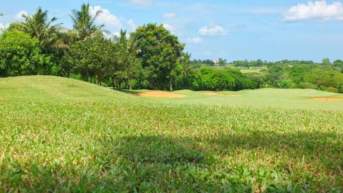a golf course with a lush green field and trees at Vipingo Ridge-Swahili Villa in Mombasa