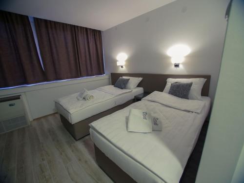 a hotel room with two beds and a window at Hotel Slavija Banja Luka in Banja Luka