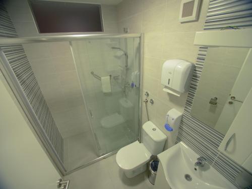 a bathroom with a shower and a toilet and a sink at Hotel Slavija Banja Luka in Banja Luka