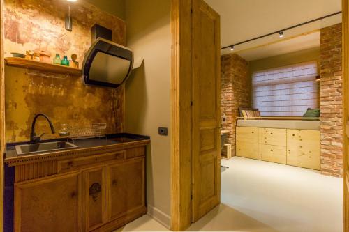 a kitchen with a sink and a tv on the wall at Nomad in Cluj-Napoca