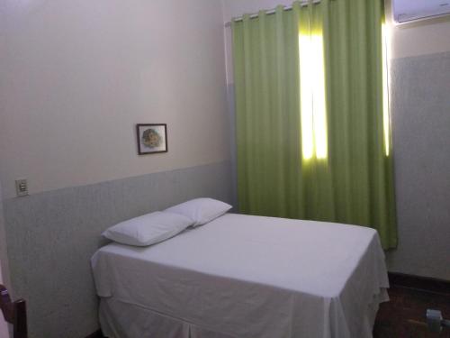 um quarto com uma cama com uma cortina verde em Hotel Imperatriz formosa em Formosa