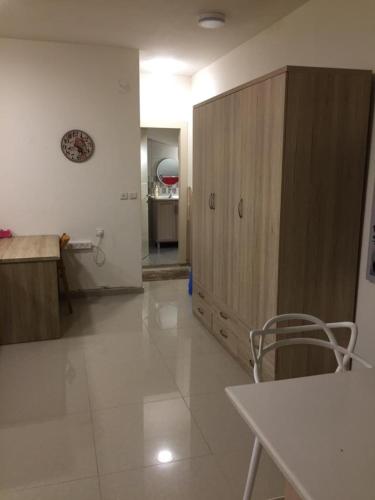 a kitchen with a large wooden cabinet in a room at בית מרום in Gan Shomeron