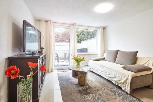 een woonkamer met een bank en een tv bij Casa Pinos City in Friedrichshafen